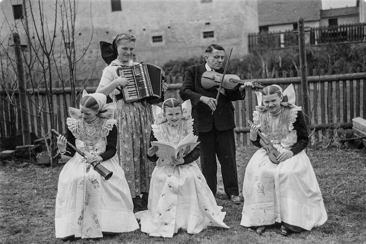 Jurij Mencl mit sorbischer Geige und musizierenden Mädchen in Tracht in Crostwitz, 1950 (Foto: Kurt Heine)